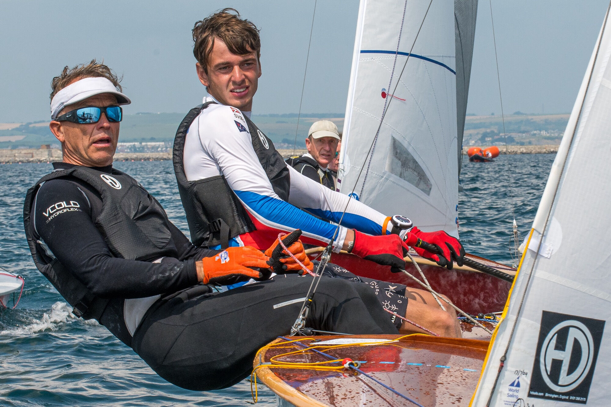 Sailing boat in waves with two sailors
